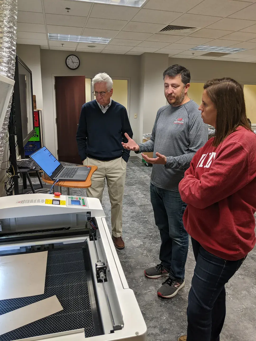 Teachers learning about operating and servicing a 3d printer machine from an expert